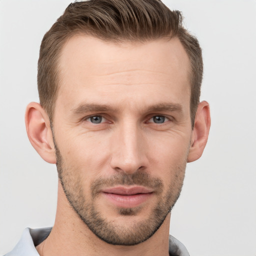 Joyful white young-adult male with short  brown hair and grey eyes