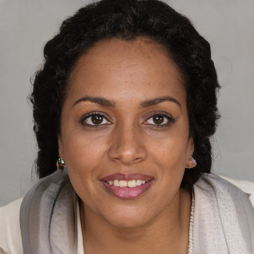 Joyful black adult female with long  brown hair and brown eyes