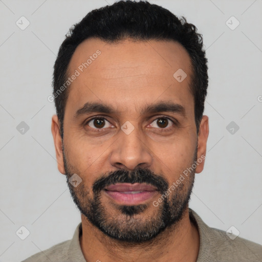Joyful latino adult male with short  black hair and brown eyes