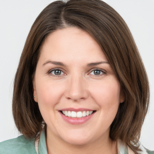 Joyful white young-adult female with medium  brown hair and grey eyes