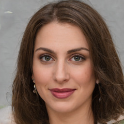 Joyful white young-adult female with long  brown hair and green eyes