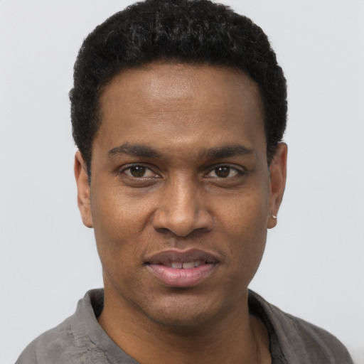 Joyful black young-adult male with short  black hair and brown eyes