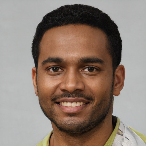 Joyful black young-adult male with short  black hair and brown eyes