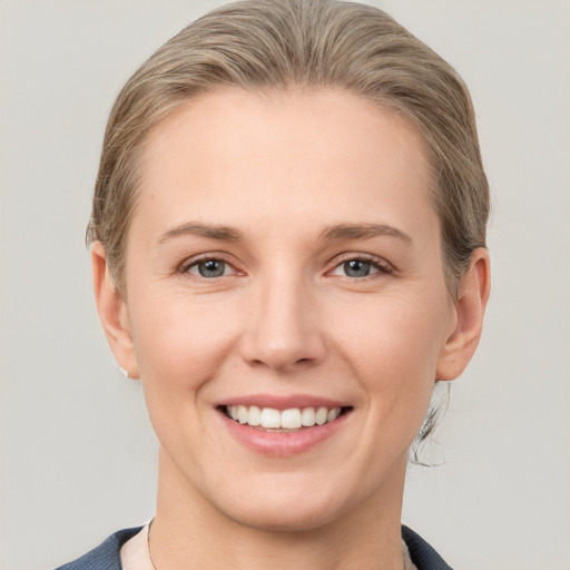 Joyful white young-adult female with short  brown hair and grey eyes