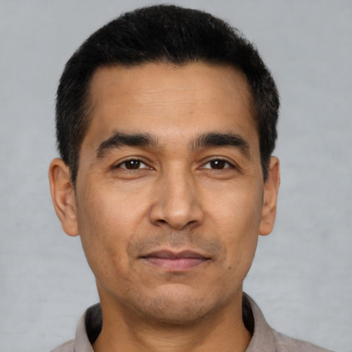 Joyful latino young-adult male with short  black hair and brown eyes
