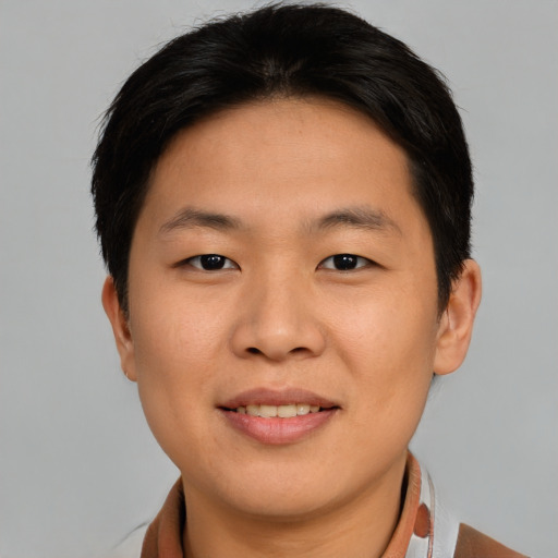 Joyful asian young-adult male with short  brown hair and brown eyes