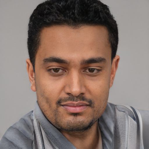 Joyful latino young-adult male with short  black hair and brown eyes