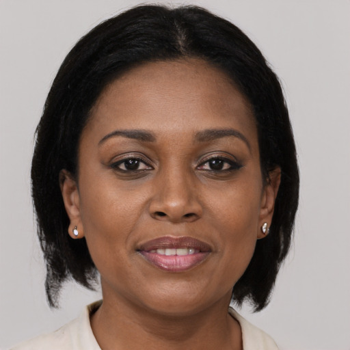 Joyful black adult female with medium  brown hair and brown eyes