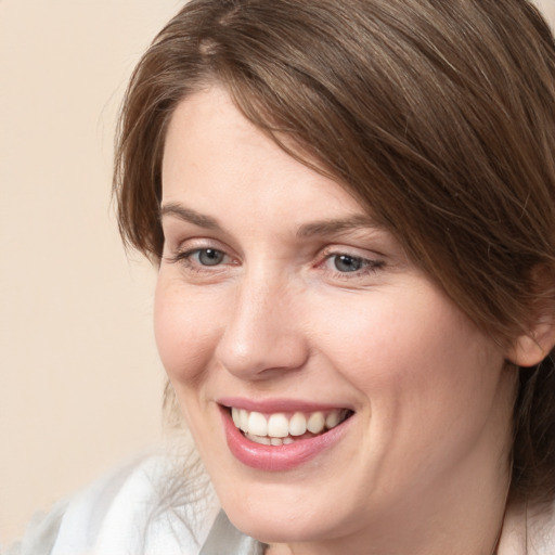 Joyful white young-adult female with medium  brown hair and grey eyes