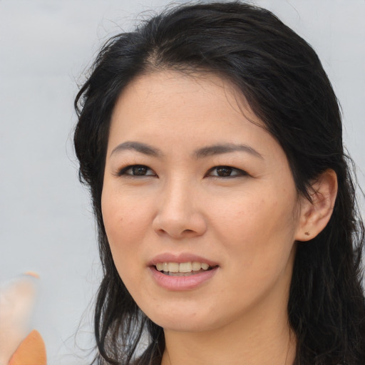 Joyful asian young-adult female with long  brown hair and brown eyes