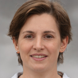 Joyful white adult female with medium  brown hair and grey eyes