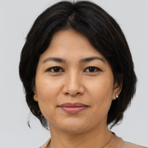 Joyful asian adult female with medium  brown hair and brown eyes
