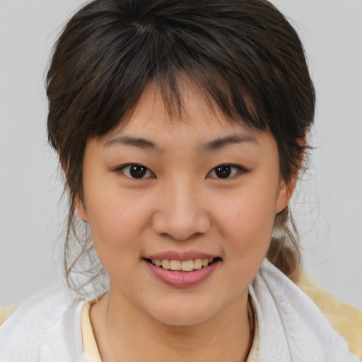 Joyful asian child female with medium  brown hair and brown eyes