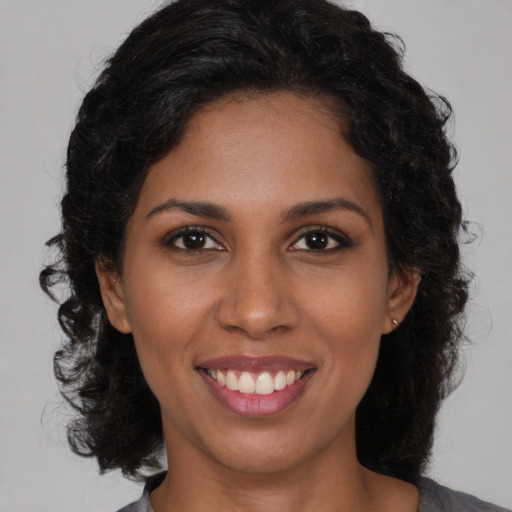 Joyful black young-adult female with medium  brown hair and brown eyes