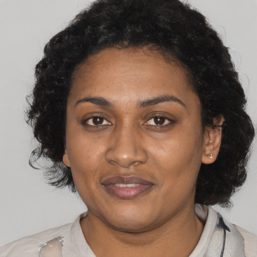 Joyful black adult female with long  black hair and brown eyes