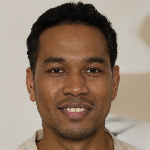 Joyful black young-adult male with short  brown hair and brown eyes