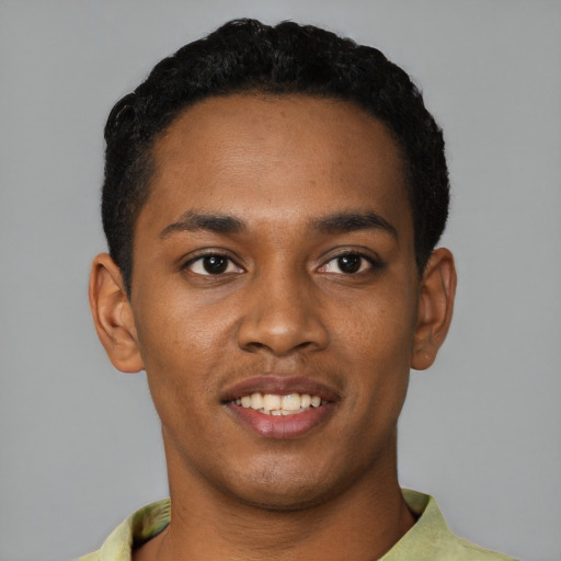 Joyful black young-adult male with short  black hair and brown eyes