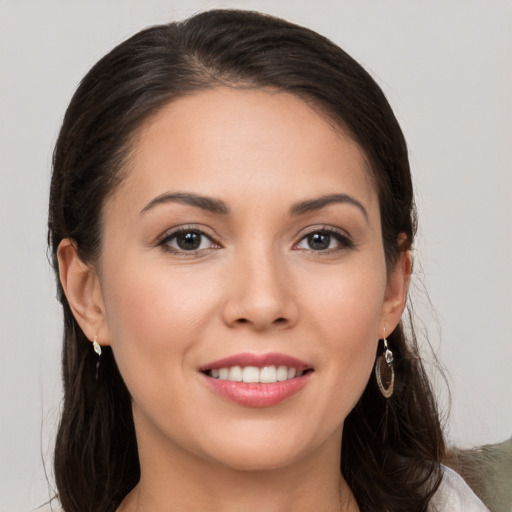 Joyful white young-adult female with long  brown hair and brown eyes