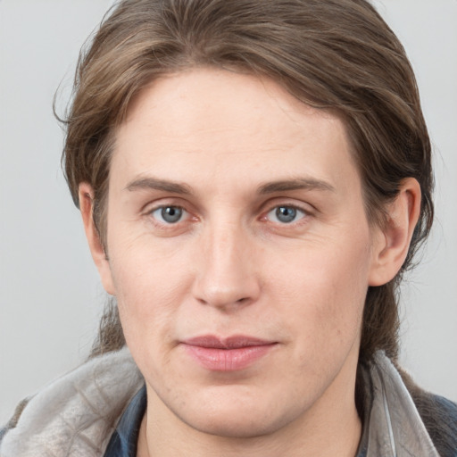 Joyful white young-adult male with medium  brown hair and grey eyes