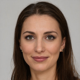 Joyful white young-adult female with long  brown hair and green eyes