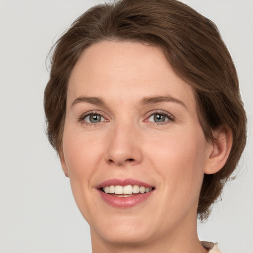 Joyful white adult female with medium  brown hair and green eyes