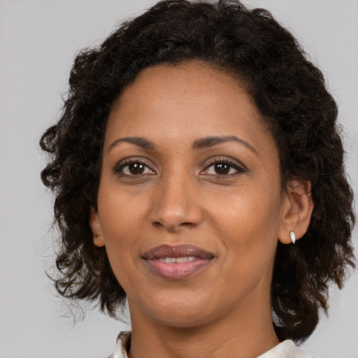 Joyful black adult female with medium  brown hair and brown eyes