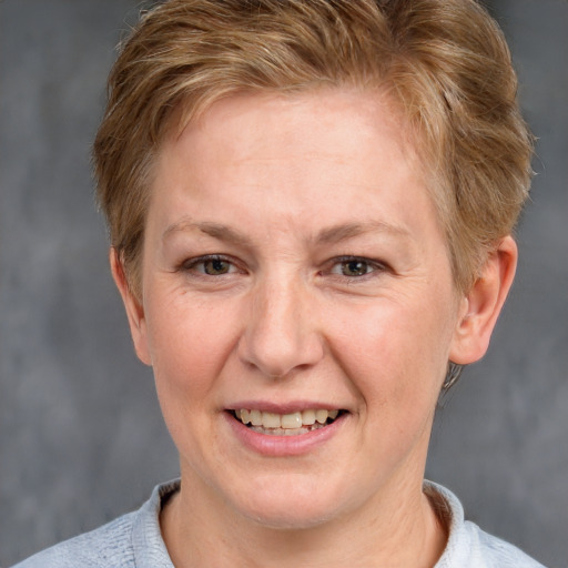 Joyful white adult female with short  brown hair and blue eyes