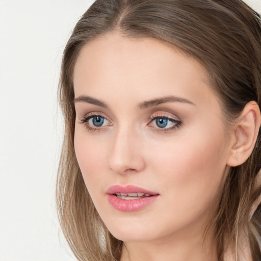 Joyful white young-adult female with long  brown hair and blue eyes