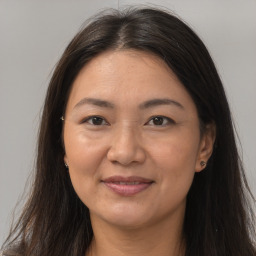 Joyful white adult female with long  brown hair and brown eyes