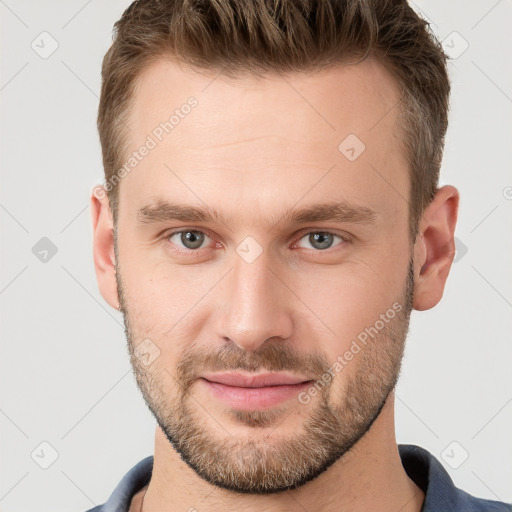 Joyful white young-adult male with short  brown hair and grey eyes