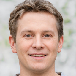 Joyful white adult male with short  brown hair and grey eyes