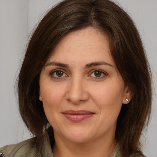 Joyful white adult female with medium  brown hair and brown eyes