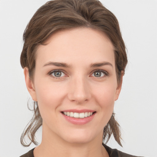 Joyful white young-adult female with medium  brown hair and grey eyes