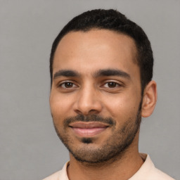 Joyful latino young-adult male with short  black hair and brown eyes