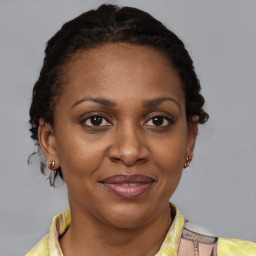 Joyful black adult female with medium  brown hair and brown eyes