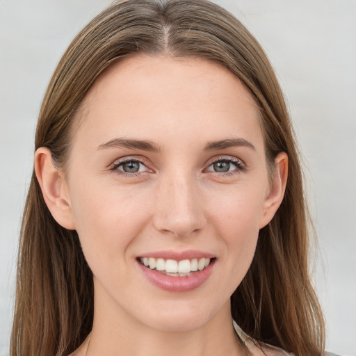 Joyful white young-adult female with long  brown hair and blue eyes