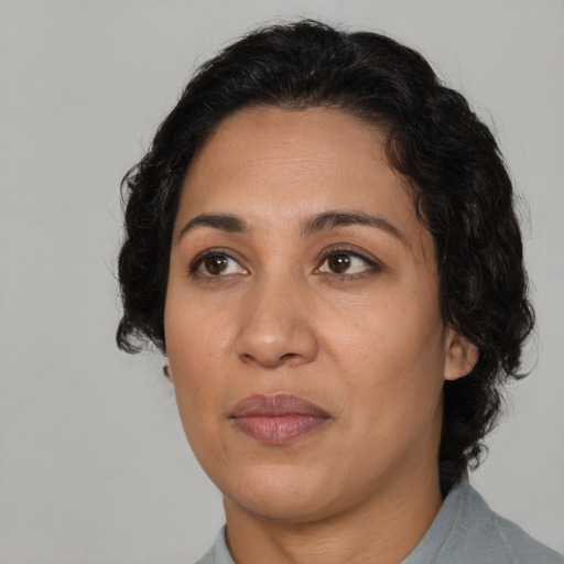 Joyful latino adult female with medium  brown hair and brown eyes