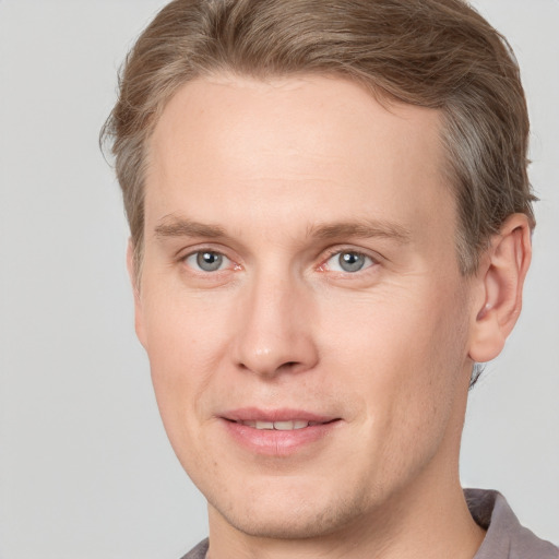 Joyful white adult male with short  brown hair and grey eyes