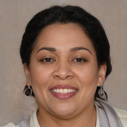 Joyful latino adult female with medium  brown hair and brown eyes