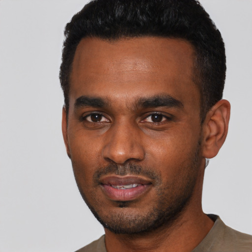 Joyful black young-adult male with short  black hair and brown eyes