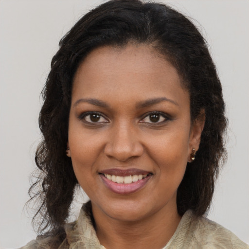 Joyful black young-adult female with long  brown hair and brown eyes