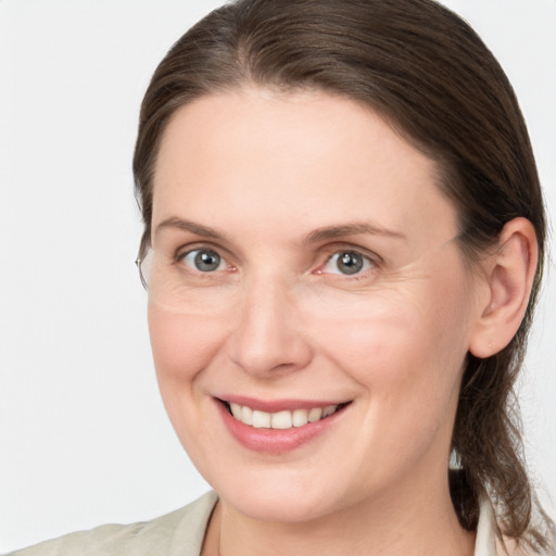 Joyful white adult female with medium  brown hair and grey eyes