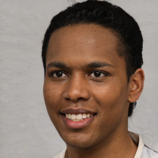 Joyful black young-adult male with short  black hair and brown eyes