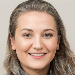 Joyful white young-adult female with long  brown hair and grey eyes