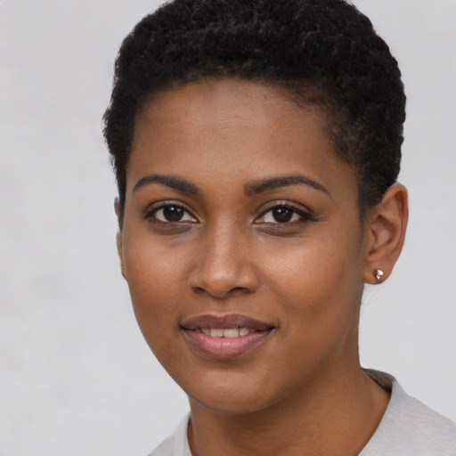 Joyful black young-adult female with short  black hair and brown eyes