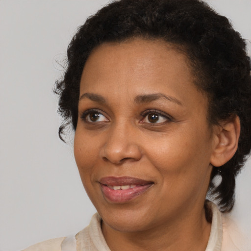 Joyful black adult female with short  brown hair and brown eyes