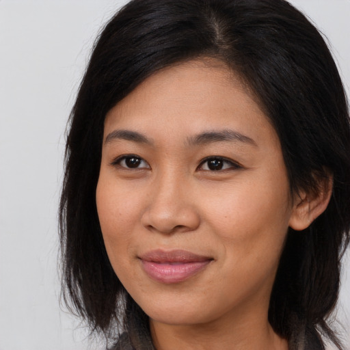 Joyful asian young-adult female with long  brown hair and brown eyes