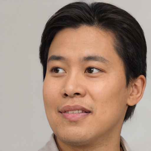 Joyful asian young-adult male with medium  brown hair and brown eyes