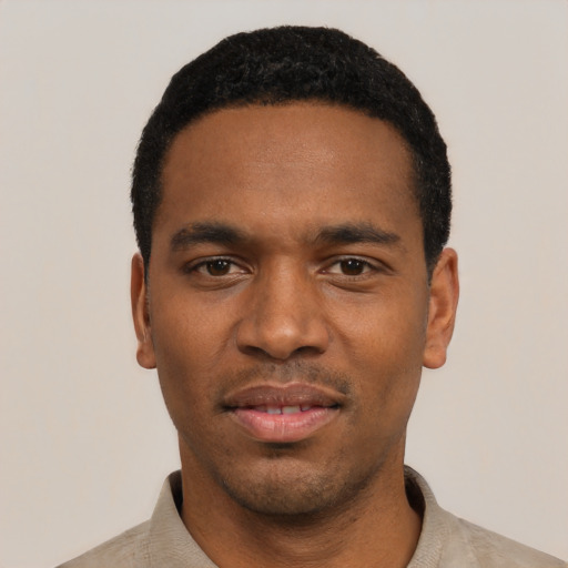 Joyful black young-adult male with short  black hair and brown eyes