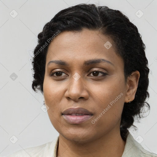 Joyful black young-adult female with long  black hair and brown eyes